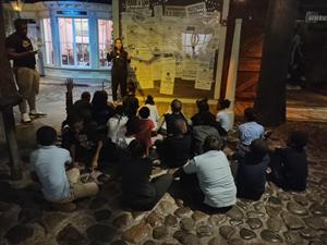 students sitting on a floor looking at a guide 